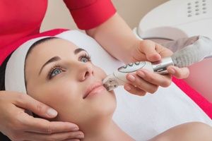 Rejuvenating facial treatment. Model getting lifting therapy massage in a beauty SPA salon. Exfoliation, Rejuvenation And Hydratation. Model and Doctor. Cosmetology.
