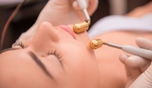 Close-up portrait of face of a young woman with fresh and clean skin lying on a table in healthy beauty spa salon getting a professional cosmetology skin care with specialized equipment